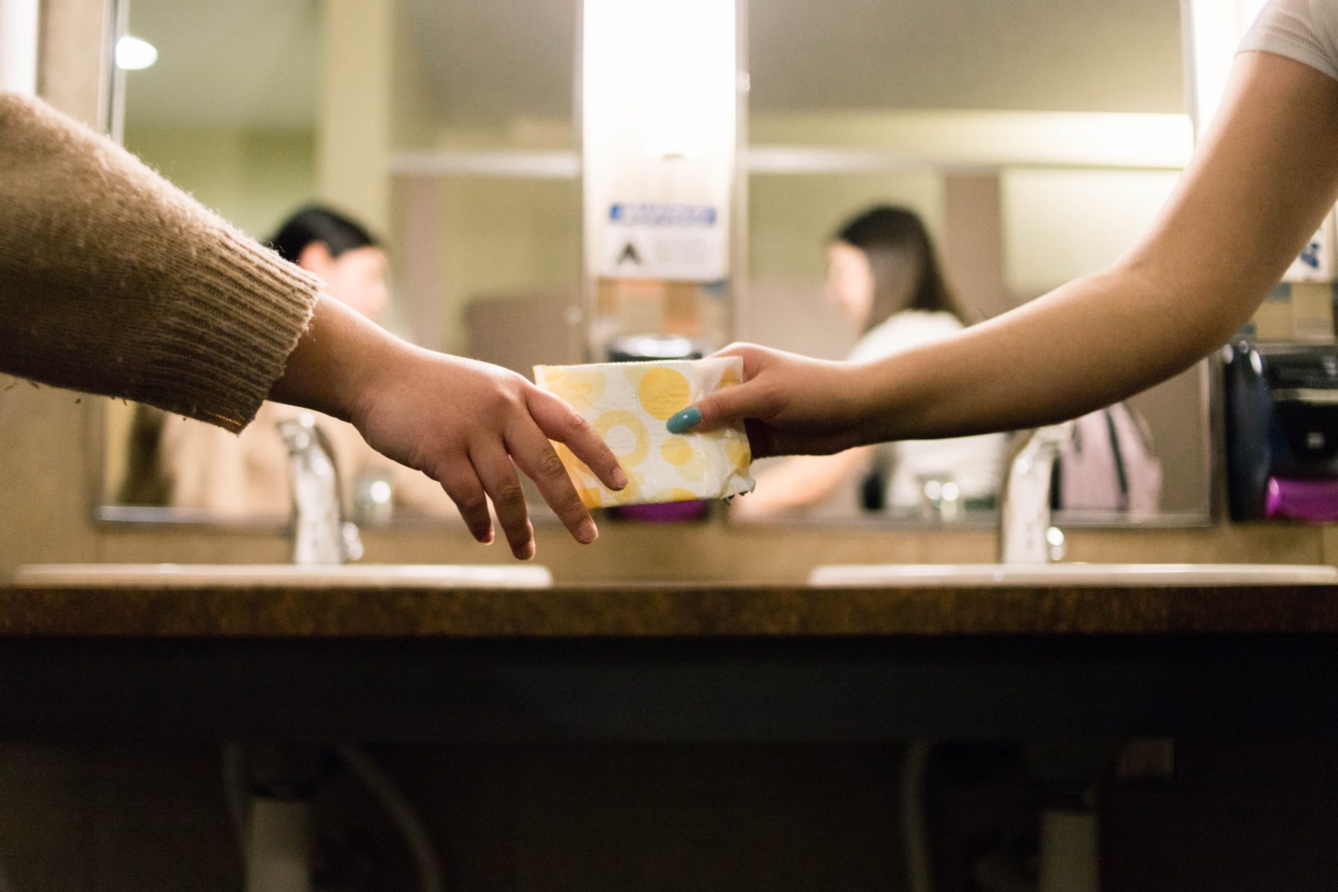 one person passing along a menstrual product to another