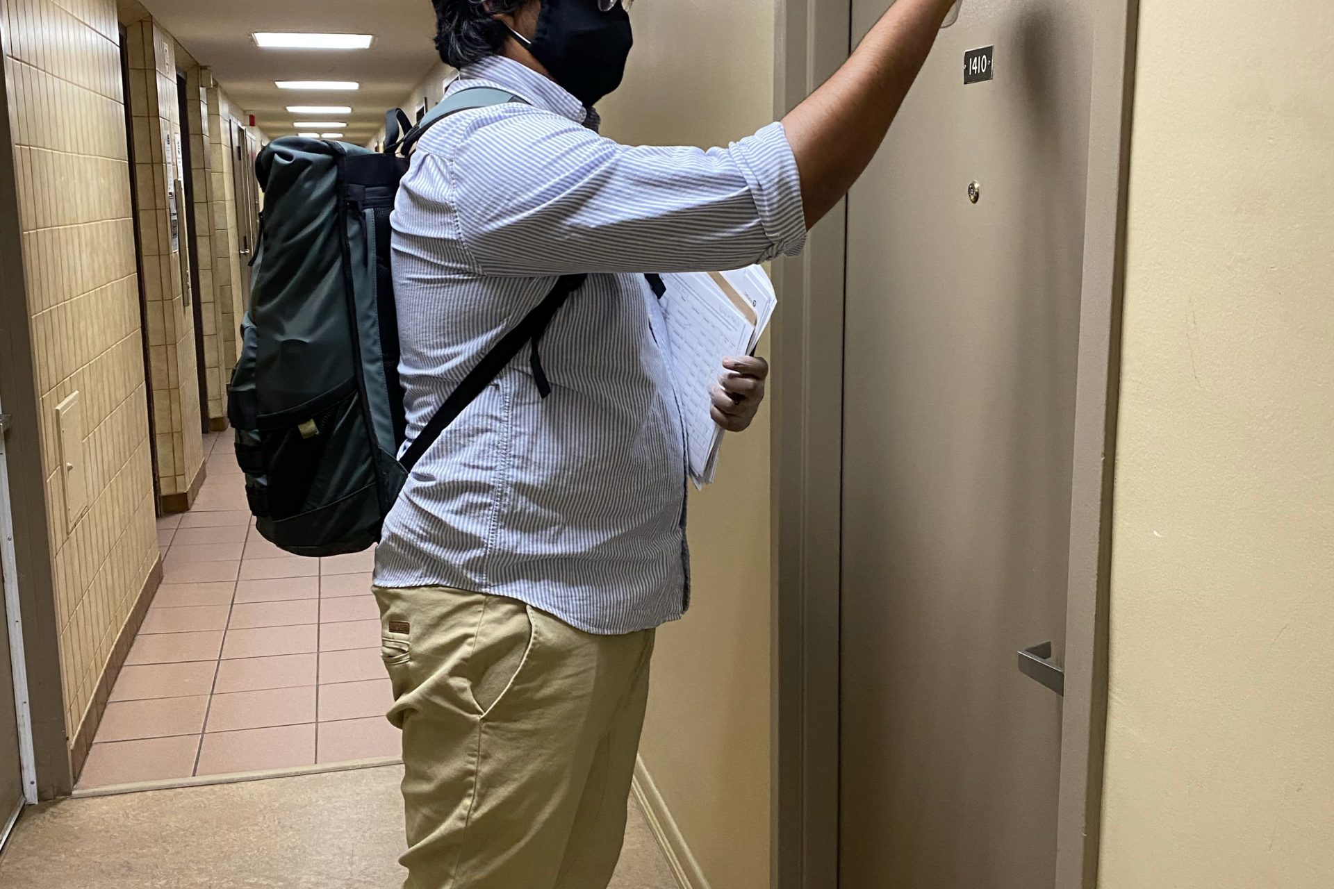 Friendly Neighbour Hotline volunteer knocking on door to deliver groceries.
