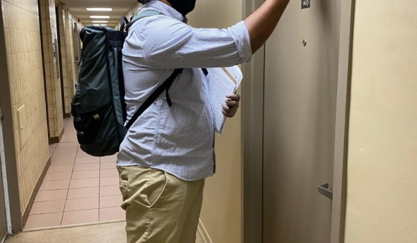 Friendly Neighbour Hotline volunteer knocking on door to deliver groceries.