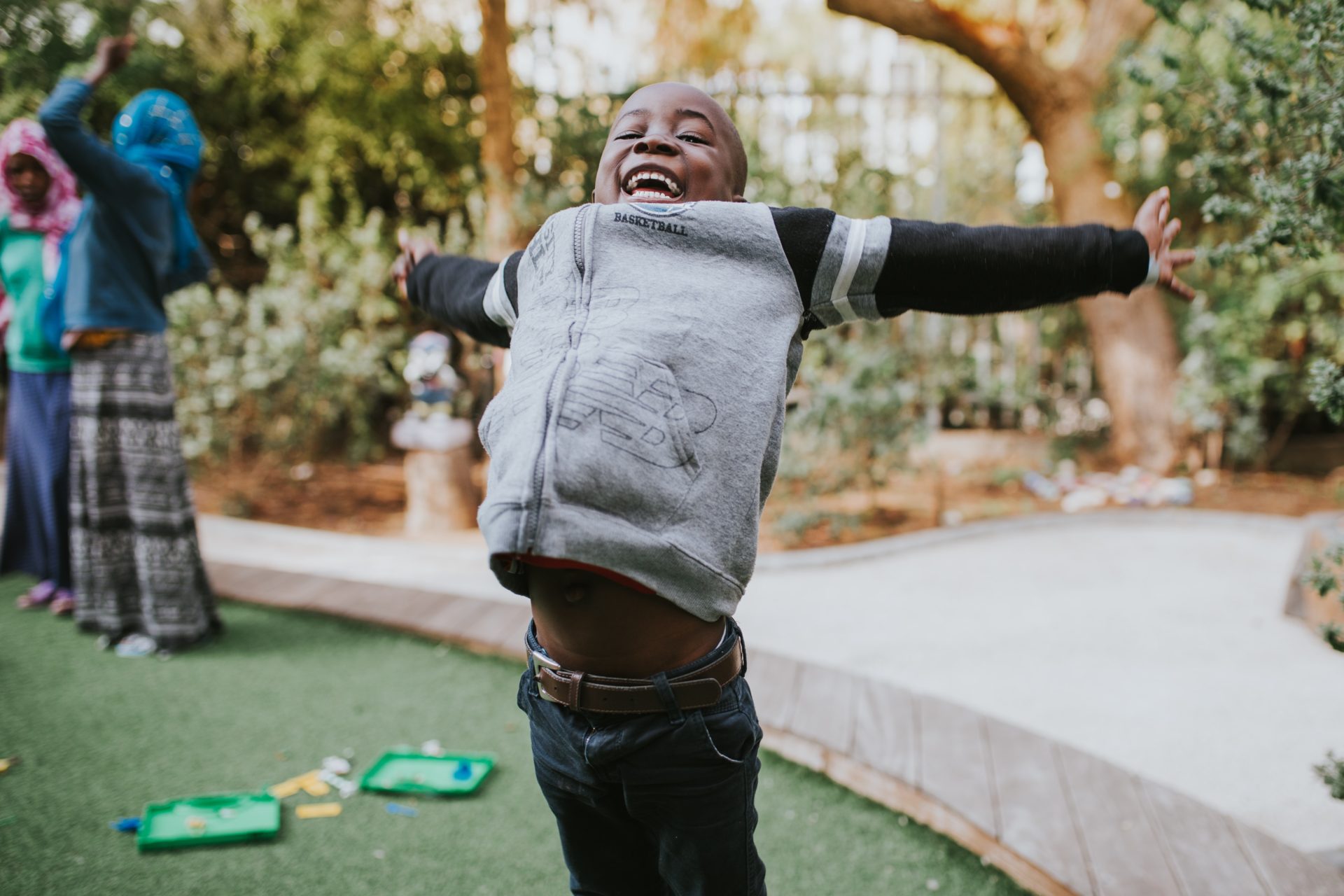 young boy jumping with his arms spread out