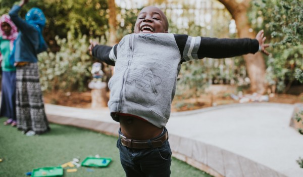 young boy jumping with his arms spread out