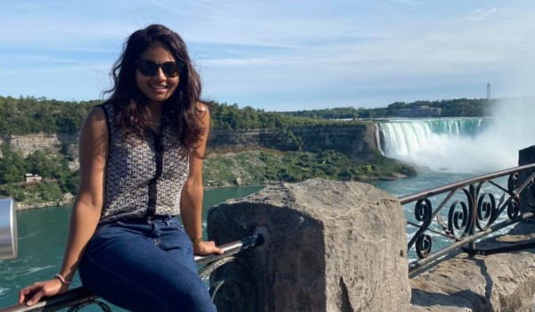 Permanent resident Marushka Loshki Nair sitting on the Niagara Falls railing.