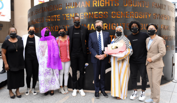 People in front of a large art piece.