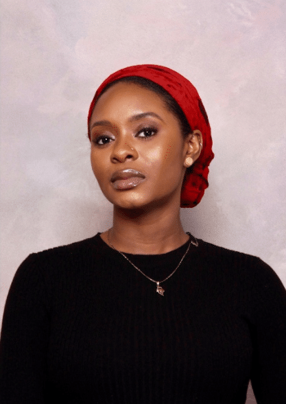A woman in a black shirt with a red scarf in her hair.